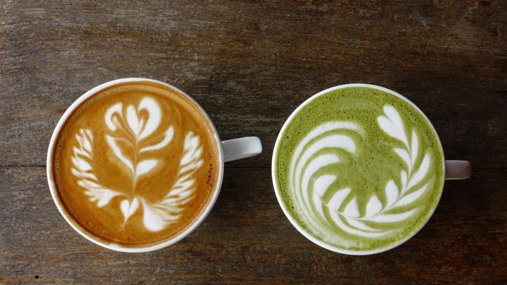 A cup of green tea matcha latte and cup of latte art coffee